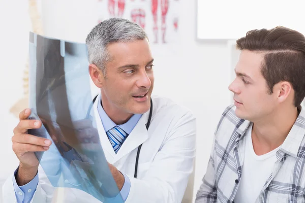 Doctor mostrando rayos X a su paciente — Foto de Stock