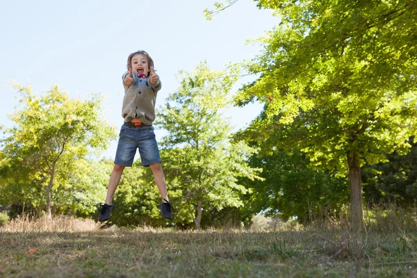 Netter kleiner Junge springt in Park — Stockfoto