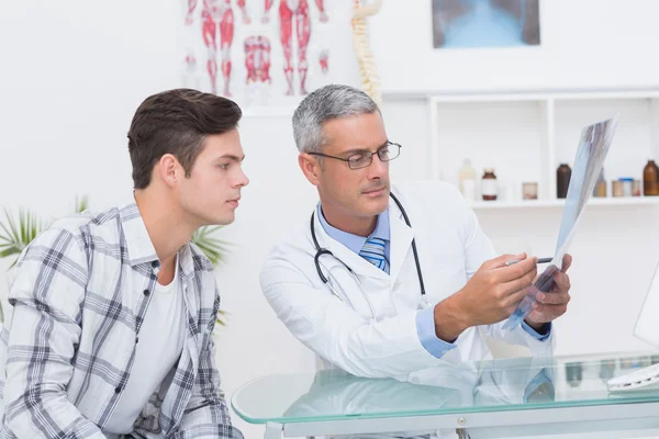 Doctor mostrando rayos X a su paciente — Foto de Stock