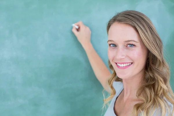 Lächelnder Lehrer schreibt auf Tafel — Stockfoto