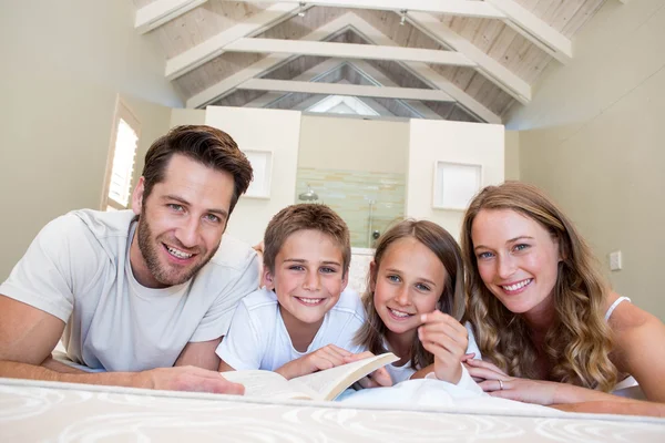 Família feliz no livro de leitura da cama — Fotografia de Stock