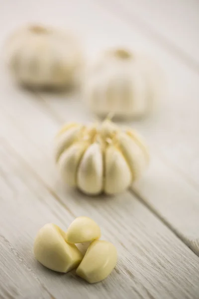 Garlic cloves and bulb on chopping board — Stock Photo, Image