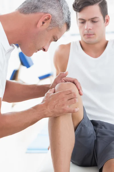 Doctor examining his patient knee — Stock Photo, Image