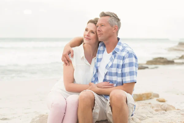 Casual couple sitting on rock — Stock Photo, Image