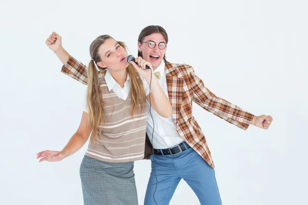 Geeky hipsters singing with microphone — Stock Photo, Image