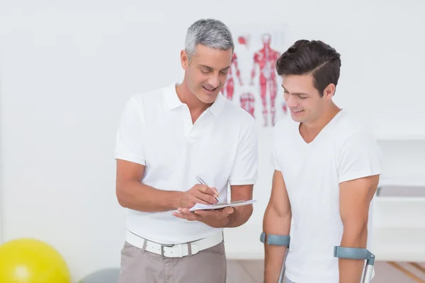 Doctor showing clipboard to patient — Stock Photo, Image