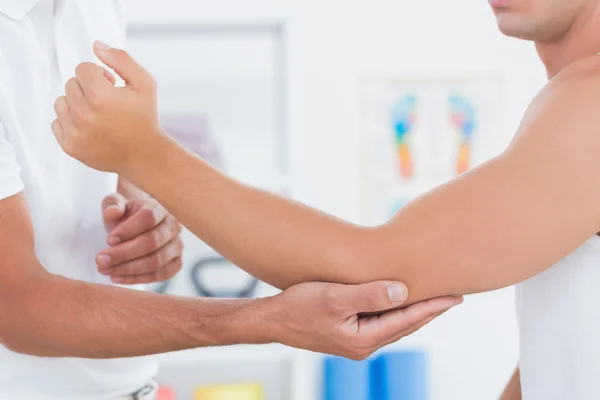 Médico examinando seu braço paciente — Fotografia de Stock