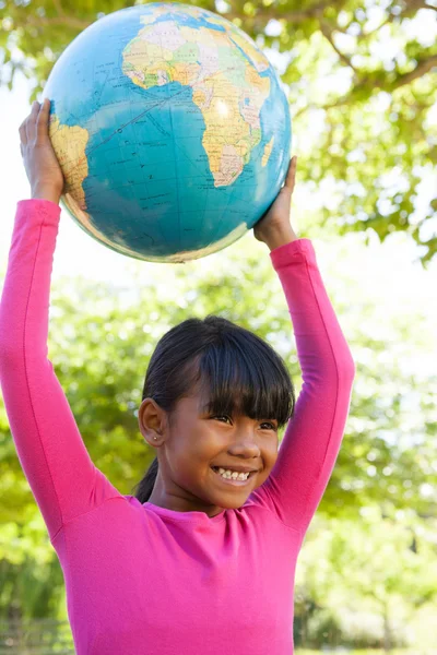 Милая маленькая девочка держит глобус — стоковое фото