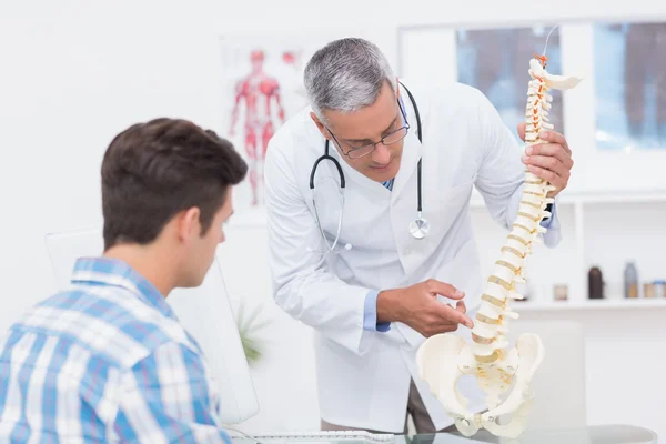 Doctor explaining a spine model to patient — Φωτογραφία Αρχείου