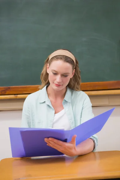 Profesora leyendo papeles en su escritorio —  Fotos de Stock