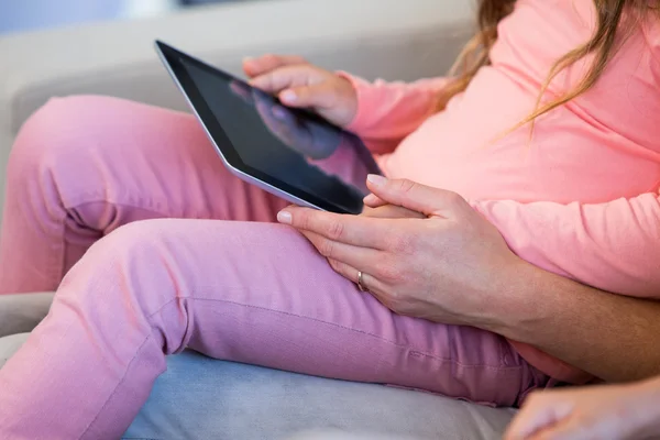 Мати і дочка використовують планшетний ПК на дивані — стокове фото
