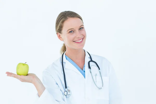 Smiling doctor offering an apple — Stock Photo, Image