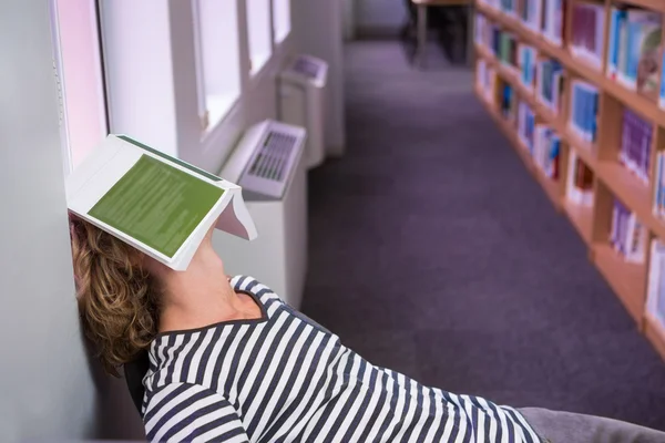 Estudante dormindo com livro em seu rosto — Fotografia de Stock