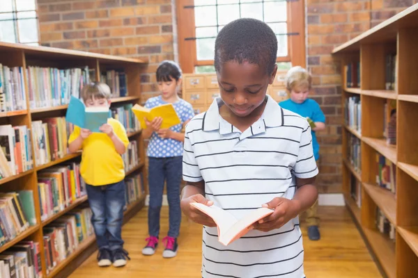 Leerlingen op zoek naar boeken in bibliotheek — Stockfoto