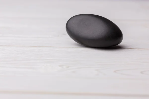 Pebble em uma mesa de madeira — Fotografia de Stock