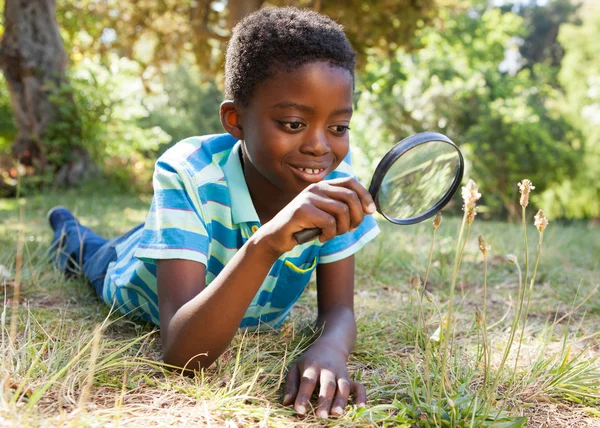 Junge schaut durch Vergrößerungsglas — Stockfoto