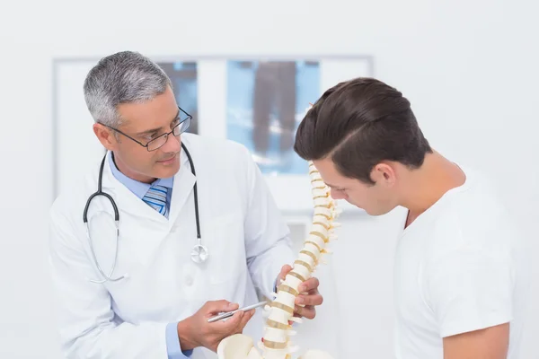 Médico explicando columna anatómica al paciente — Foto de Stock