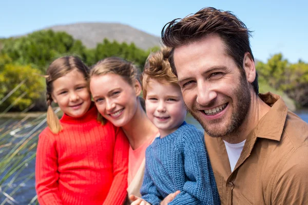 Familia feliz en un lago — Foto de Stock