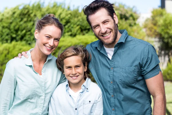 Familia feliz sonriendo a la cámara — Foto de Stock