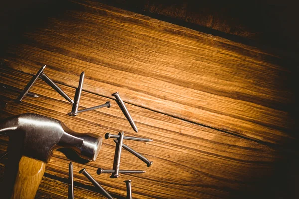 Martillo y clavos dispuestos en la mesa — Foto de Stock