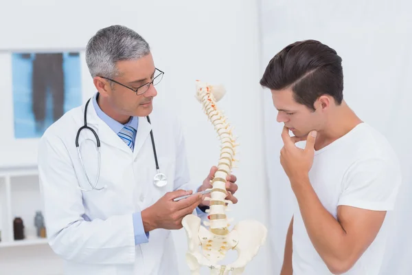 Läkaren förklarar anatomiska ryggraden till patient — Stockfoto