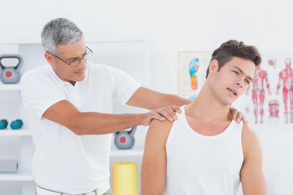 Médico examinando seu pescoço paciente — Fotografia de Stock