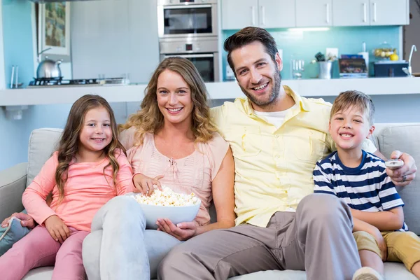 Lycklig familj på soffan tittar på tv — Stockfoto