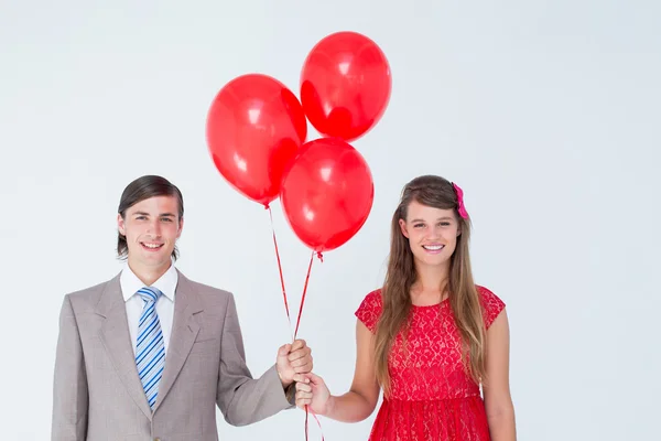 Geeky paar bedrijf rode ballonnen — Stockfoto