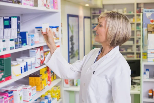 Apotheker nimmt Medikamente aus dem Regal — Stockfoto