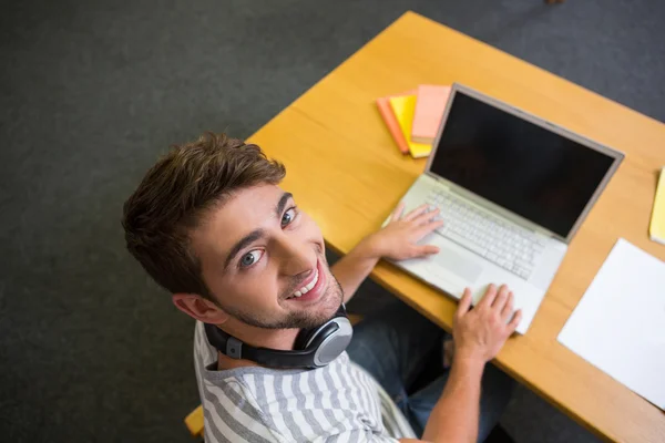 Estudante estudando na biblioteca com laptop — Fotografia de Stock