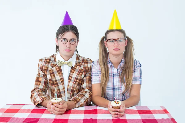 Unsmiling geeky hipsters celebrating birthday — Stock Photo, Image