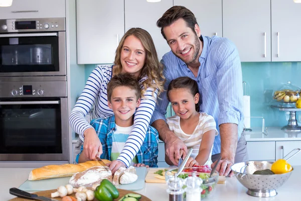 Família feliz preparando legumes juntos — Fotografia de Stock