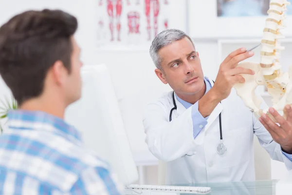 Médico explicando columna anatómica al paciente — Foto de Stock