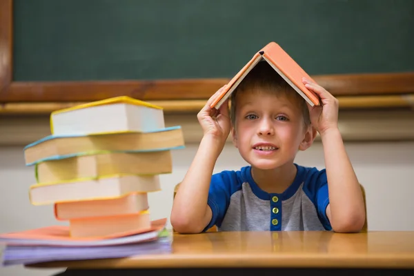 Lindo chico con libro en la cabeza —  Fotos de Stock