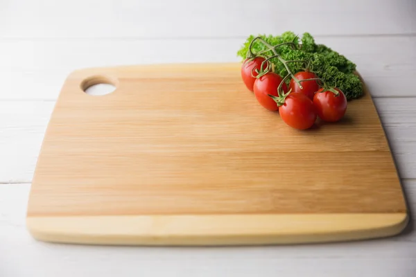 Chopping board tomatoes and parsley — Stock Photo, Image