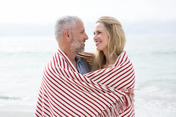 Paar glimlachen bij elkaar op het strand — Stockfoto