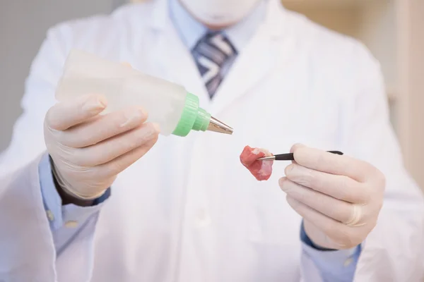 Wissenschaftler streut Flüssigkeit auf Fleisch — Stockfoto