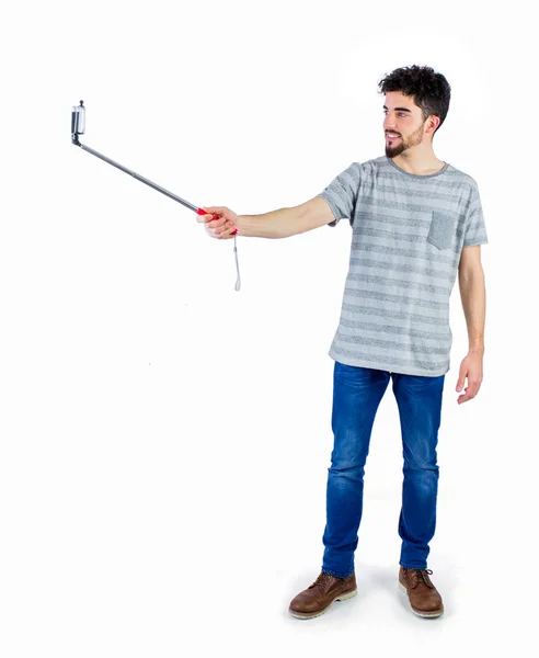 Casual man met een selfie stok — Stockfoto