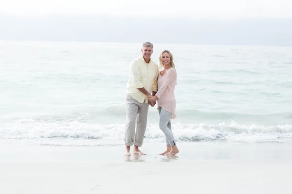 Casal feliz em pé junto ao mar — Fotografia de Stock