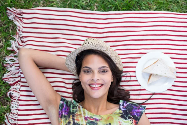 Smiling beautiful brunette lying on the blanket — Stock Photo, Image