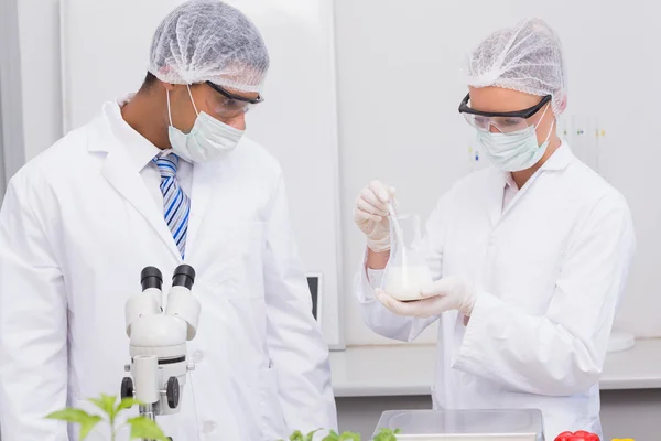 Scientists looking at white precipitate — Stock Photo, Image