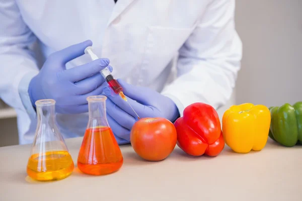 Científico inyectando verduras — Foto de Stock