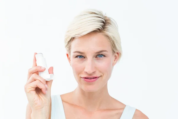 Mujer bonita sosteniendo inhalador sonriendo a la cámara — Foto de Stock