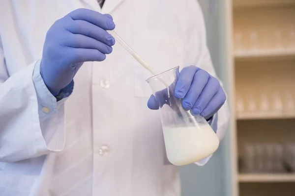 Naukowiec badanie biały płyn — Zdjęcie stockowe