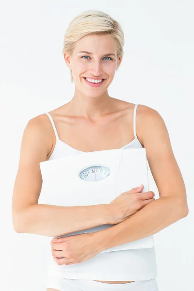 Smiling woman holding scales looking at camera — Stock Photo, Image