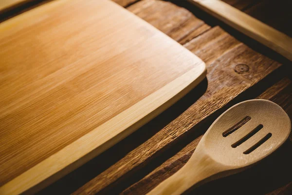 Tábua de corte com utensílios de madeira — Fotografia de Stock