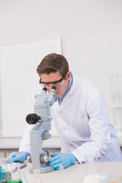 Wetenschapper die door een microscoop kijkt — Stockfoto