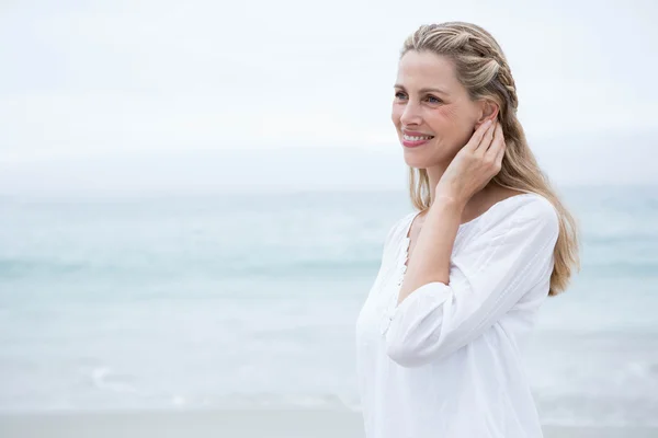 Lachende blonde vrouw op het strand — Stockfoto