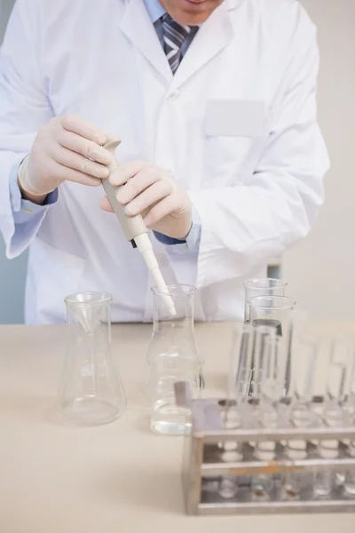 Cientista fazendo experiências em erlenmeyer — Fotografia de Stock