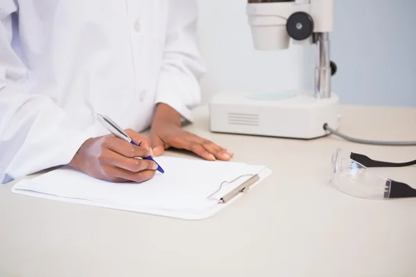 Concentrated scientist taking notes — Stock Photo, Image